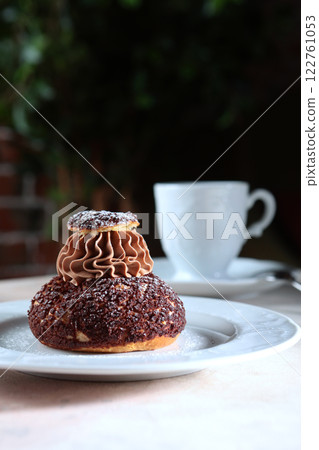 French Shu pastry with peach jam. Custard cake. A cup of coffee. A confectionery product. French Shu pastry with peach jam. Custard cake. A cup of coffee. A confectionery product. 122761053