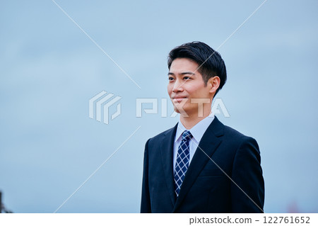A young man in a suit looking into the distance 122761652
