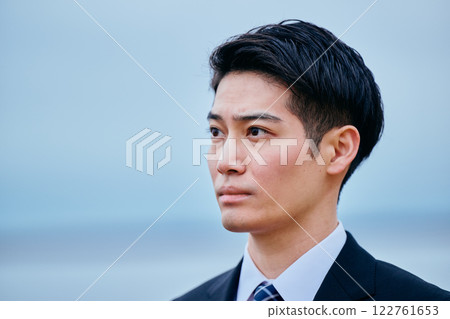 A young man in a suit looking into the distance 122761653