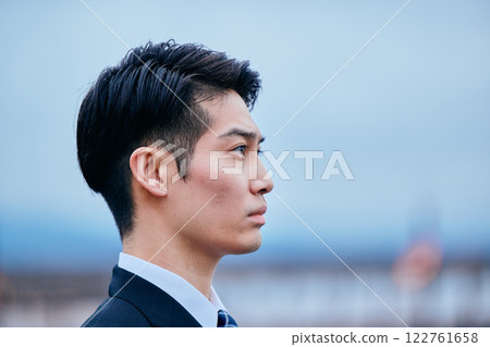 A young man in a suit looking into the distance A young man in a suit looking into the distance 122761658