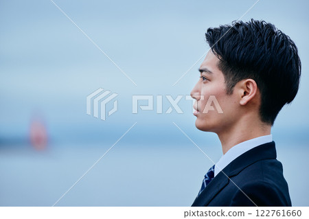 A young man in a suit looking into the distance A young man in a suit looking into the distance 122761660