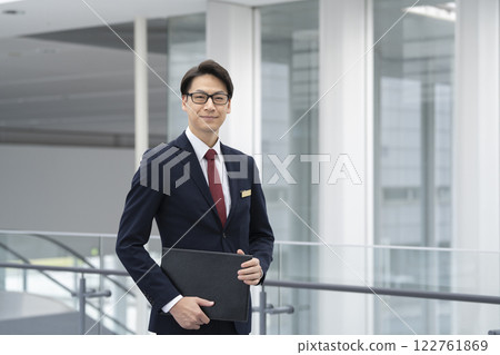 Businessman in his 40s looking at the camera, front desk staff, concierge image 122761869