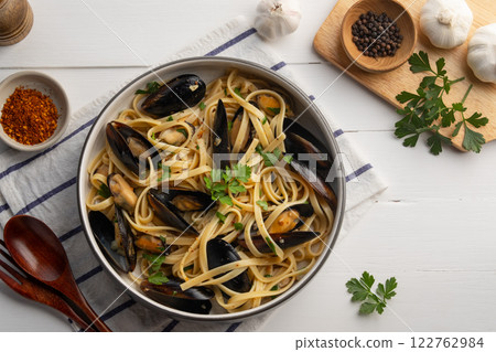 Green mussel fettuccine pasta with white wine and chilli garlic in a plate.Top view. Green mussel fettuccine pasta with white wine and chilli garlic in a plate.Top view. 122762984