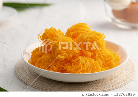 Close up Crispy Sweet egg floss or Golden Thread Egg,Shredded Egg Yolk Tart in white plate. 122762989