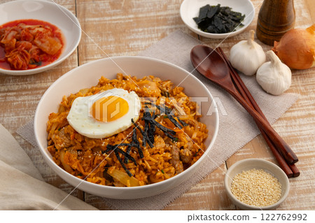 Kimchi fried rice with pork topped with fried egg sesame seed and Crispy Seaweed in white plate.Korean food. 122762992