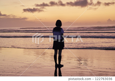 黃昏時分沿著海灘散步的高中女生 122763036