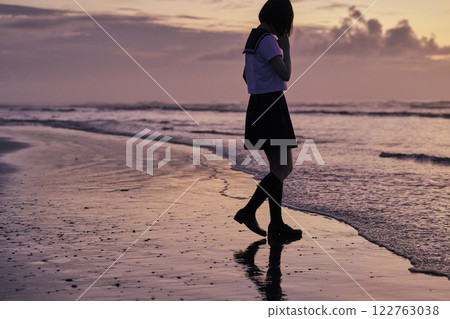High school girls walking along the beach at dusk 122763038