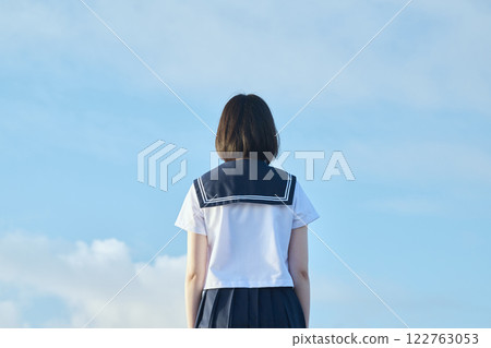 以藍天和大海為背景站立的高中女生 以藍天和大海為背景站立的高中女生 122763053