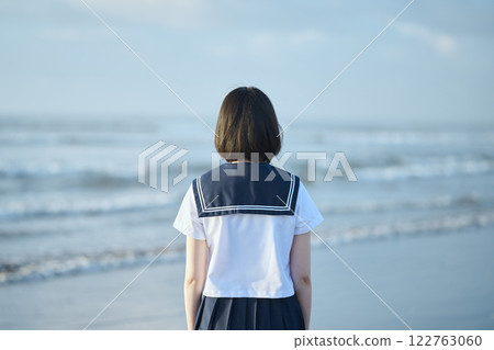 A high school girl standing with the blue sky and sea in the background A high school girl standing with the blue sky and sea in the background 122763060