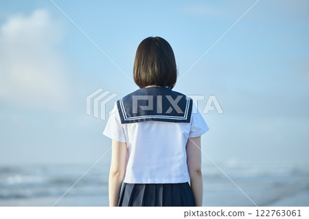 A high school girl standing with the blue sky and sea in the background A high school girl standing with the blue sky and sea in the background 122763061