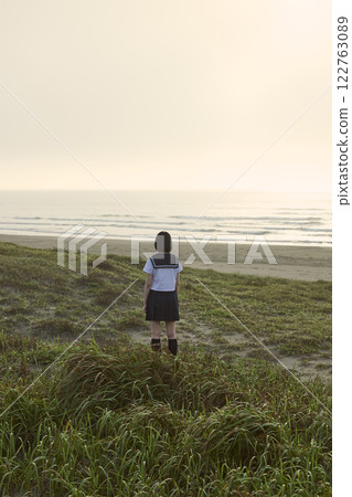 Back view of a high school girl gazing at the sea Back view of a high school girl gazing at the sea 122763089