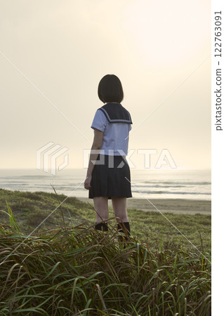 Back view of a high school girl gazing at the sea Back view of a high school girl gazing at the sea 122763091