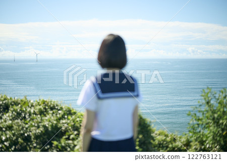 Back view of a high school girl gazing at the sea 122763121