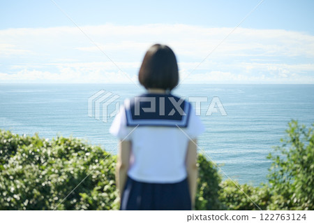 Back view of a high school girl gazing at the sea 122763124