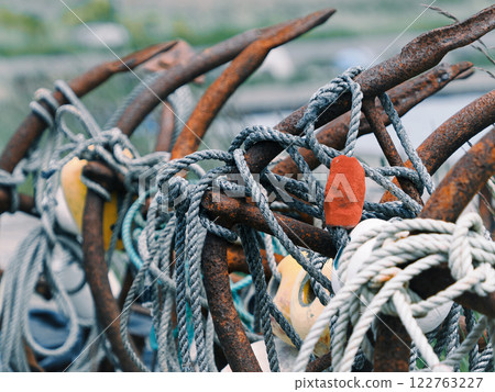 Scenery of rusty anchors and ropes at a fishing port 122763227