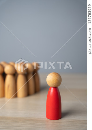 The red man stands away from the group, rejected and exiled. Social exclusion, rejection, workplace discrimination, loneliness, isolation, and being an outcast. Social pressure, and nonconformity. 122763929