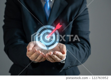 Businessman holding an arrow at a target. Concept of a goal and its achievement. Achieving objectives, business strategy, career ambitions, success planning, financial targets 122763952