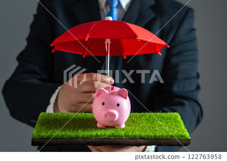 Businessman protects piggy bank with red umbrella. Savings insurance. Risk management, insurance coverage, investment safety, wealth preservation, and economic stability. Businessman protects piggy bank with red umbrella. Savings insurance. Risk management, insurance coverage, investment safety, wealth preservation, and economic stability. 122763958