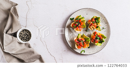 Poke bowls in pita bread with salmon and avocado on a plate top view web banner 122764033