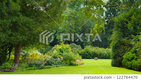 Beautiful garden with coniferous and deciduous trees. 122764470