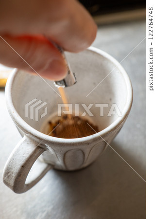 人把咖啡粉放進杯子裡(手)垂直 人把咖啡粉放進杯子裡(手)垂直 122764748
