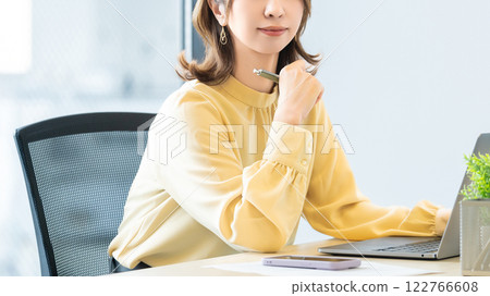 Smiling woman/businesswoman doing desk work 122766608