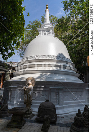 Buddha statue placed in front of white pagoda of Gangaramaya Temple Buddha statue placed in front of white pagoda of Gangaramaya Temple 122766978