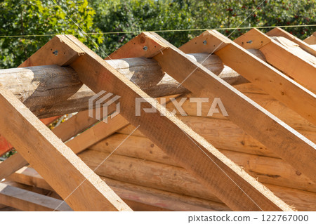 Log house roof structure is under construction. Wooden rafters 122767000