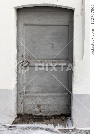 Grungy old gray wooden door is in old stone wall 122767006