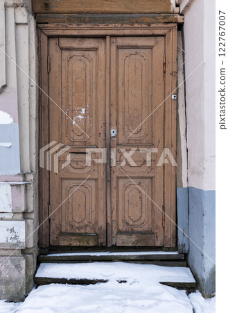 Grungy old brown wooden door is in weathered wall Grungy old brown wooden door is in weathered wall 122767007
