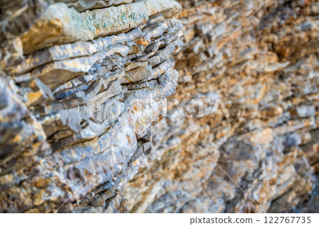 Layered rock texture in Budva, Montenegro. Sedimentary rocks with rugged surface of gray and brown. Natural formation of layers and cracks, geological structure. Layered rock texture in Budva, Montenegro. Sedimentary rocks with rugged surface of gray and brown. Natural formation of layers and cracks, geological structure. 122767735