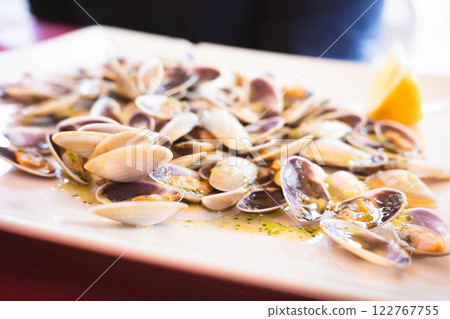 Freshly prepared clams dish on a white plate Freshly prepared clams dish on a white plate 122767755