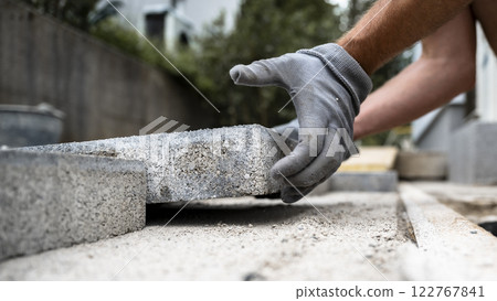 Laying concrete pavers 122767841