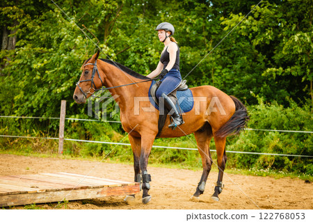 Jockey girl doing horse riding on countryside meadow Jockey girl doing horse riding on countryside meadow 122768053