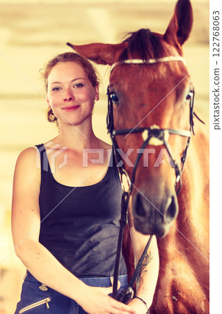 Young woman girl in stable with horse. Young woman girl in stable with horse. 122768063