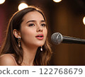 Young female singer performing on stage with microphone and spotlight Generated AI. 122768679