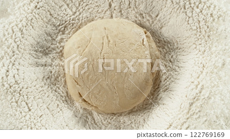 Freeze motion of falling yeast dough into heap of flour. Freeze motion of falling yeast dough into heap of flour. 122769169