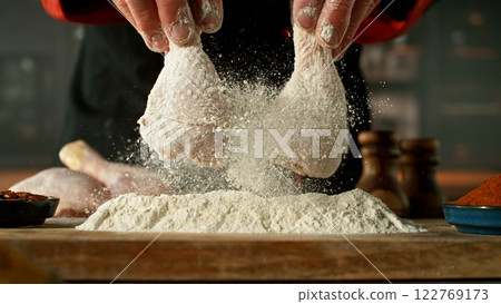 Freeze motion of chef processing raw chicken meat. 122769173