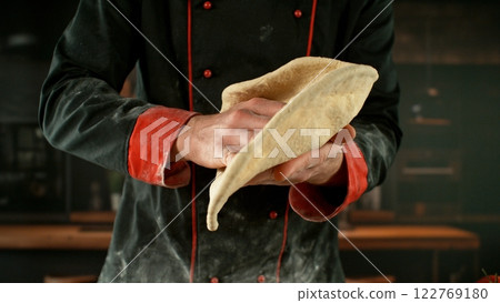 Freeze motion of baker processing yeast dough on pizza. 122769180