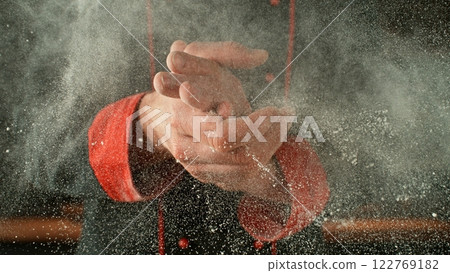 Freeze motion of baker clapping his hands with flour exploding. Freeze motion of baker clapping his hands with flour exploding. 122769182