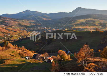 Amazing autumn morning scenery in mountains with meadow and colorful trees on foreground and fog underfoot. National Natural Park Synevyr, Carpathian Mountains, Ukraine. Beautiful autumn background Amazing autumn morning scenery in mountains with meadow and colorful trees on foreground and fog underfoot. National Natural Park Synevyr, Carpathian Mountains, Ukraine. Beautiful autumn background 122769389