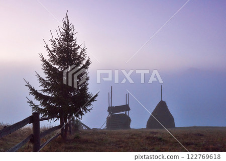 Amazing mountain landscape with fog and a haystack in autumn 122769618