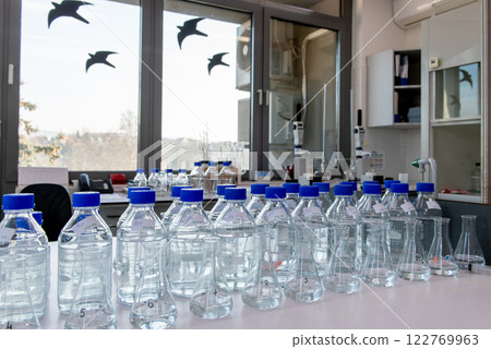 Laboratory equipment. Laboratory storage bottles with blue polypropylene cap on white table. Laboratory equipment. Laboratory storage bottles with blue polypropylene cap on white table. 122769963