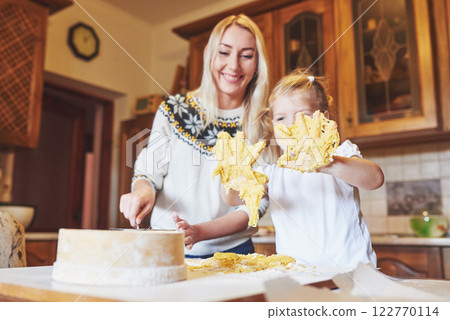 Happy daughter and mom in the kitchen bake cookies 122770114