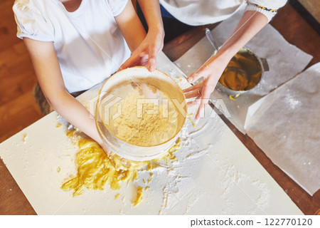 A happy girl wears a dough. Baby make dinner in chef suit 122770120