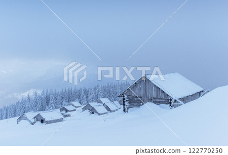 Cabin in the mountains in winter. Mysterious fog. In anticipation of holidays. Carpathians. Ukraine, Europe Cabin in the mountains in winter. Mysterious fog. In anticipation of holidays. Carpathians. Ukraine, Europe 122770250
