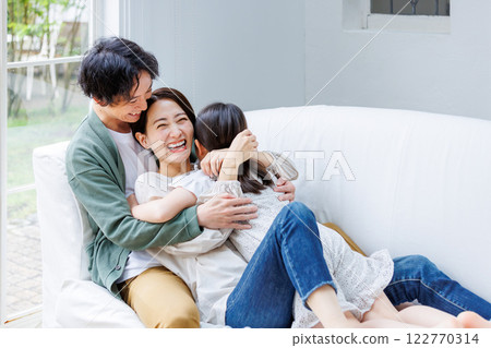 Smiling parent and child sitting on the sofa in the living room Smiling parent and child sitting on the sofa in the living room 122770314