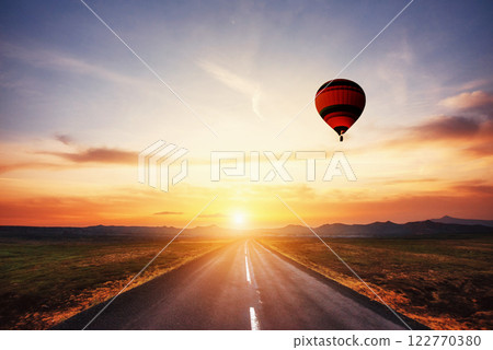 Asphalt road along and Colored ball in the sky at sunset Asphalt road along and Colored ball in the sky at sunset 122770380