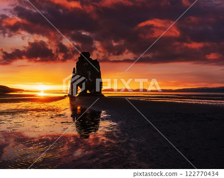 Is a spectacular rock in the sea on the Northern coast of Iceland. Legends say it is a petrified troll. On this photo Hvitserkur reflects in the sea water after the midnight sunset 122770434