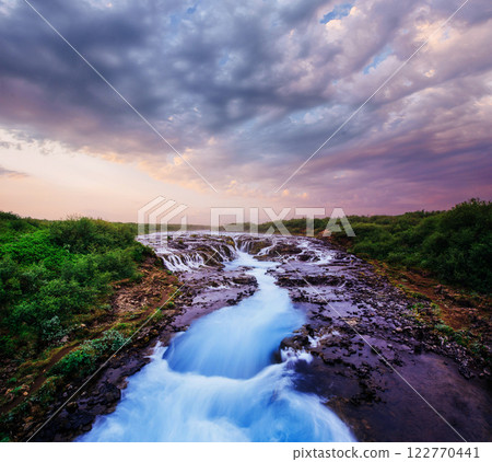 Gentle slopes of snow-capped mountains and glaciers. Wonderful Iceland in the spring. Fantastic dramatic clouds 122770441